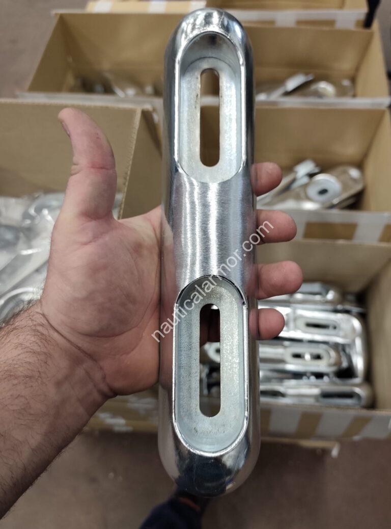 Hand holding a machined bolt-on Nautical Armor sacrificial anode BLT 23800270E above boxes of anodes