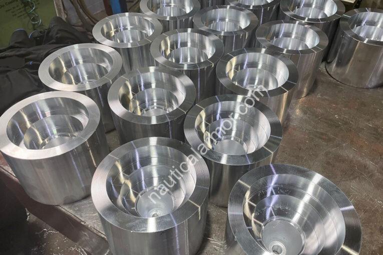 Nautical Armor multiple large machined propeller anode parts arranged on a metal workbench