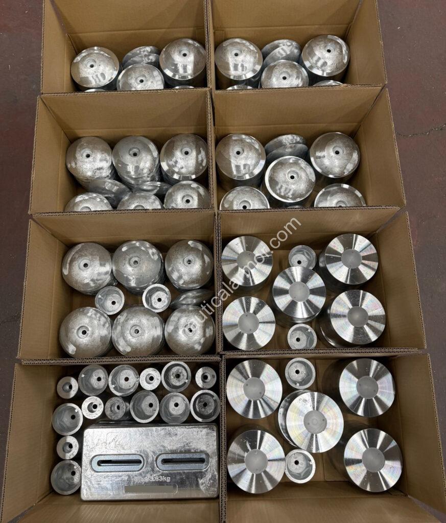 Nautical Armor open boxes filled with mixed sacrificial anodes (rudder, stern, propeller, and plate types) arranged for packing.