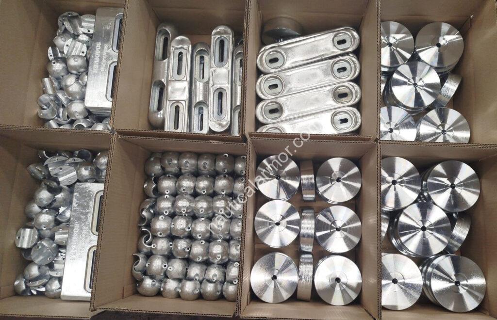 Open boxes of Nautical Armor shaft, stern, plate, and bolt-on sacrificial anodes staged for packing.