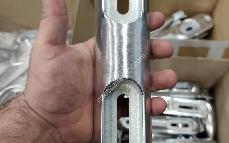 Hand holding a machined bolt-on Nautical Armor sacrificial anode BLT 23800270E above boxes of anodes